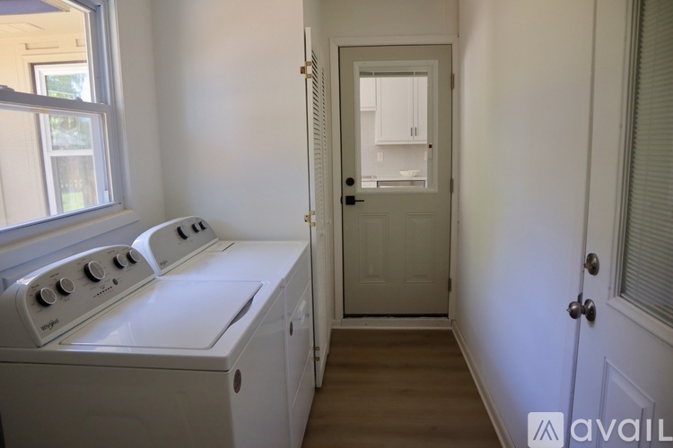 A white oven in a kitchen with a door leading to a hallway.