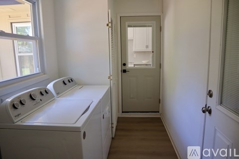 A white oven in a kitchen with a door leading to a hallway.