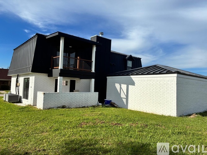 A modern house with a black and white exterior is shown.