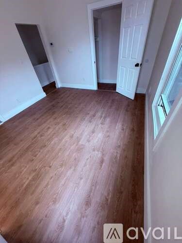 A room with wooden flooring and white walls.