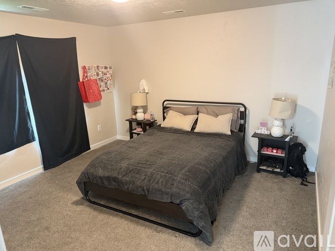 A bedroom with a bed, nightstands, and a backpack.