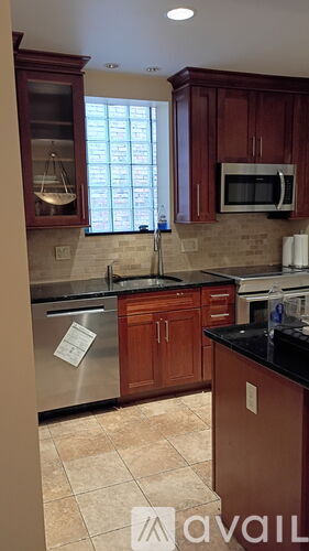 A kitchen with brown cabinets and a black counter top.