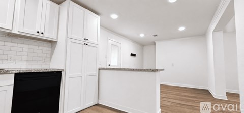 A kitchen with white cabinets and a black oven.
