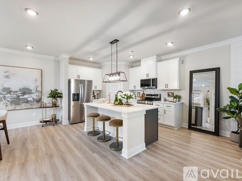 A modern kitchen with a large island and stools.