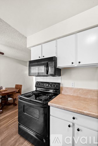 A kitchen with a black stove and white cabinets.