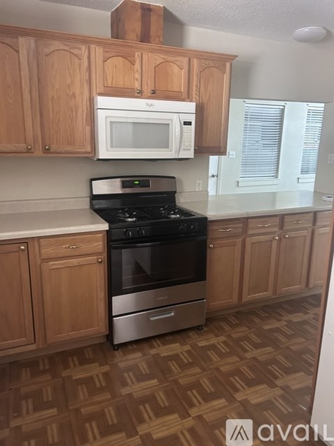 A kitchen with wooden cabinets and a black stove top oven.