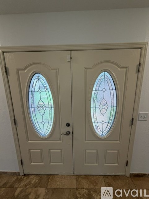 A pair of white doors with stained glass windows.