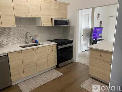 A kitchen with wooden cabinets and a black stove top oven.
