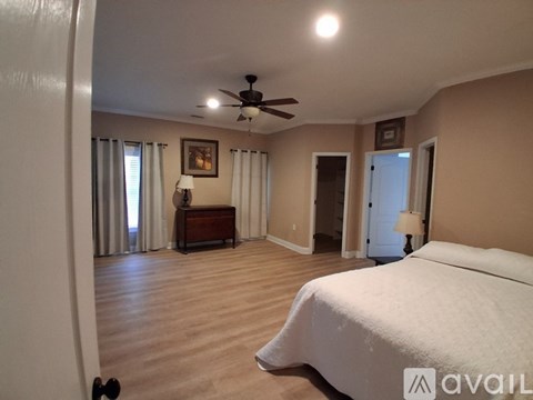 A bedroom with a bed, dresser, and ceiling fan.