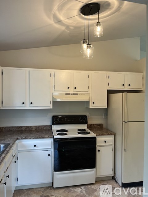 A kitchen with white cabinets and a black stove top oven.