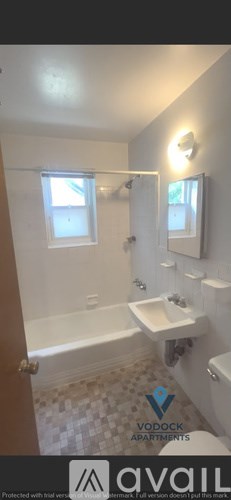 A bathroom with a bathtub, sink, and mirror.