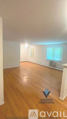 A room with wooden floors and a window with blinds.