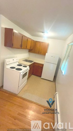 A small kitchen with wooden cabinets and a white stove.