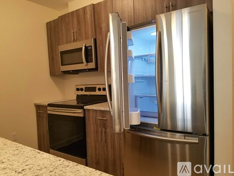 A kitchen with a stainless steel refrigerator and microwave oven.