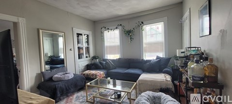 A living room with a black couch and a coffee table.