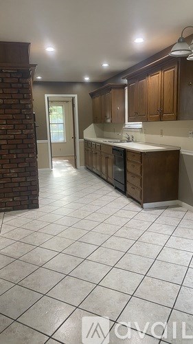 A kitchen with brown cabinets and a white tile floor.