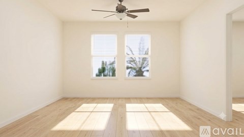 A room with a ceiling fan and two windows.