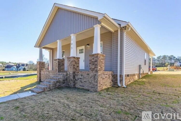 A house with a porch and a stone pillar.