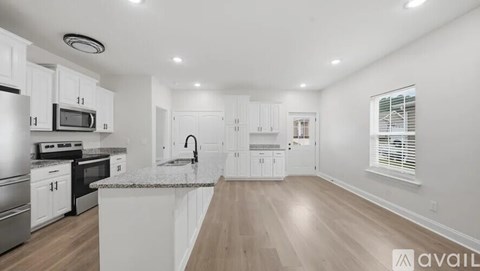 A kitchen with white cabinets and a granite countertop.