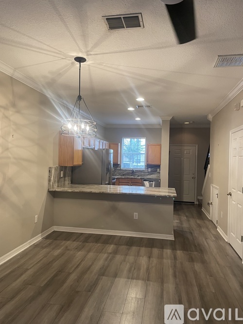 A room with a wooden floor and a ceiling fan with lights.