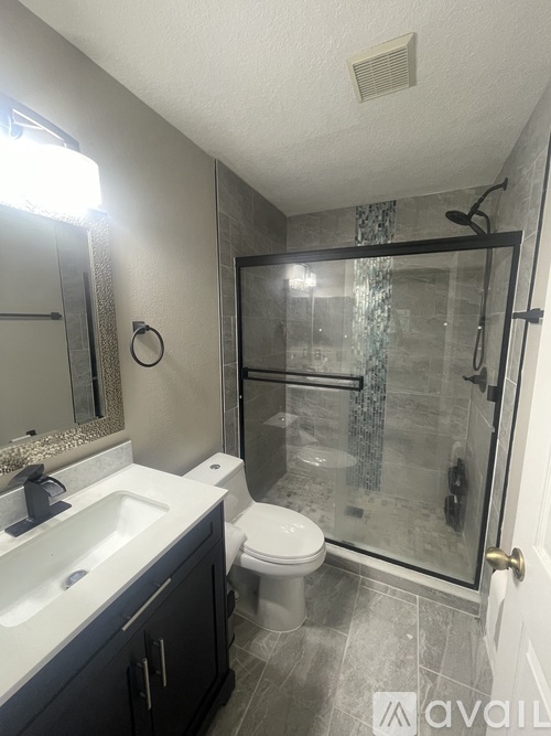 A bathroom with a toilet, sink, and shower.