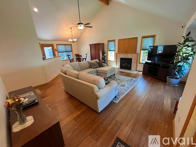A living room with a couch, a coffee table, and a television.