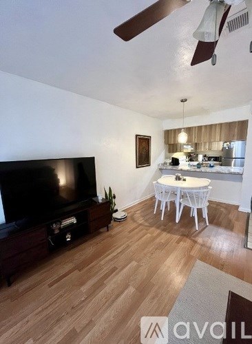 A living room with a television and a dining table.
