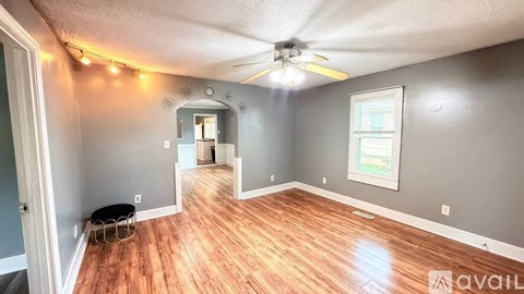 A kitchen with white cabinets and a wooden floor.