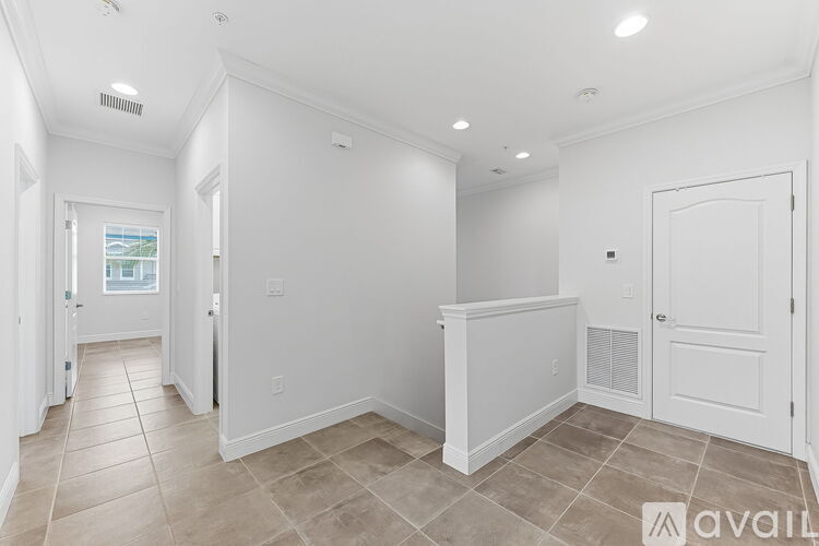 A spacious room with white walls and a tiled floor.