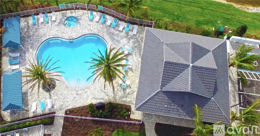 A swimming pool surrounded by palm trees and a modern building.