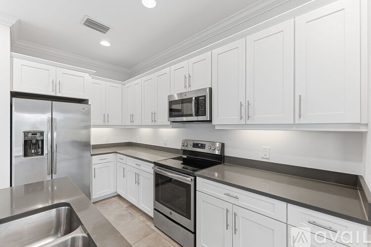 A modern kitchen with white cabinets and stainless steel appliances.