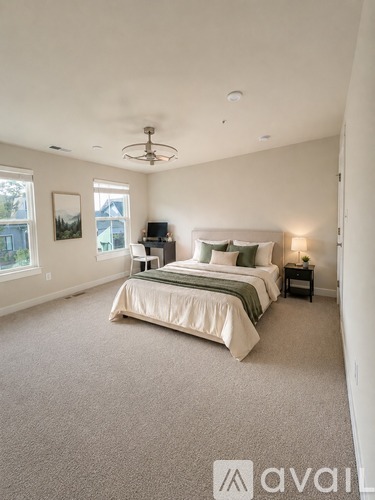 A bedroom with a large bed and a ceiling fan.