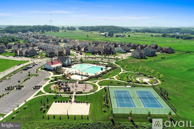 A bird's eye view of a housing development with a tennis court and a pool.