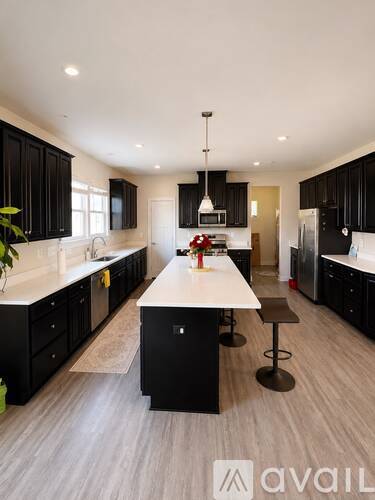 A modern kitchen with black cabinets and a central island.