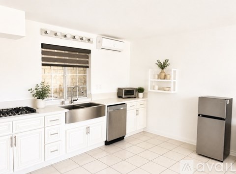 A kitchen with white cabinets and a stainless steel dishwasher.