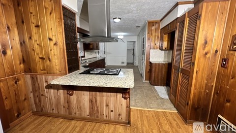 A kitchen with wooden cabinets and a marble countertop.