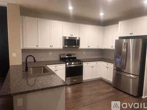 A kitchen with white cabinets and stainless steel appliances.