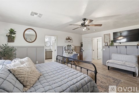 A bedroom with a large bed and a ceiling fan.