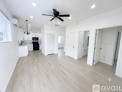 A spacious room with a ceiling fan and lighting fixtures.