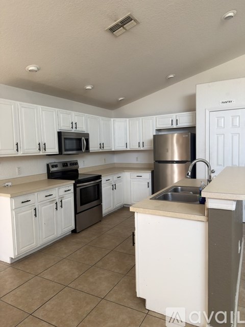 A kitchen with white cabinets and appliances.