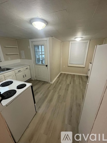 A kitchen with a stove top oven and a refrigerator.