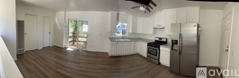A kitchen with white cabinets and a stainless steel refrigerator.