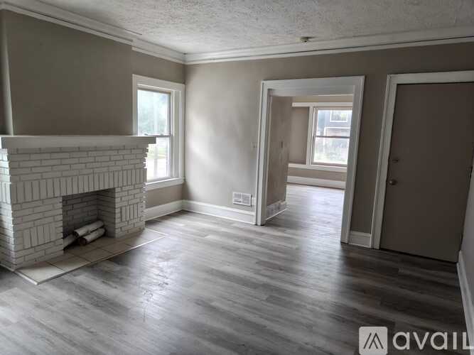 A living room with a fireplace and wood flooring.