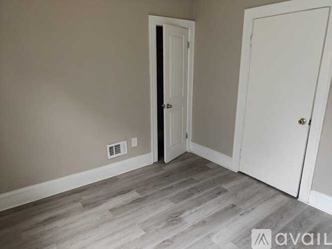 A room with a white door and a white door with a black handle.
