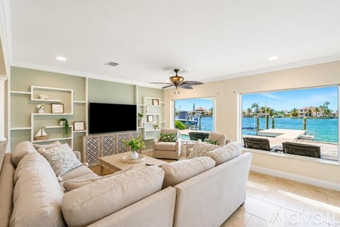 A living room with a large couch and a view of the water.