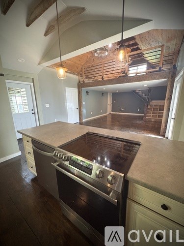 A modern kitchen with a large island and stove top.