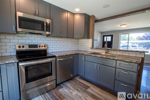 A kitchen with a stove top oven and microwave above it.