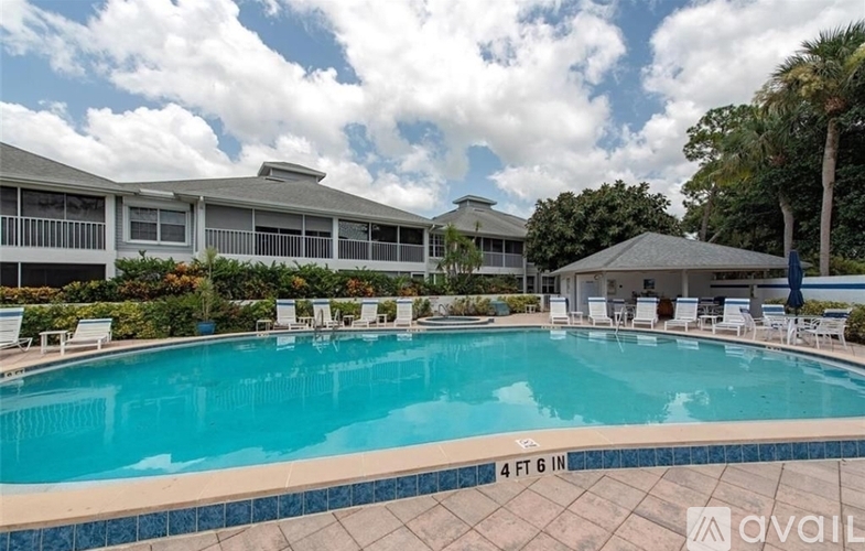 A swimming pool in front of a house with a sign that says "available".