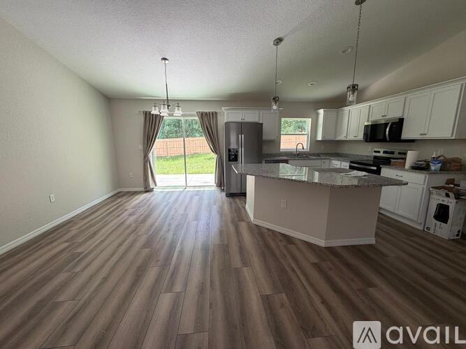 A kitchen with a wooden floor and white cabinets is available for rent.