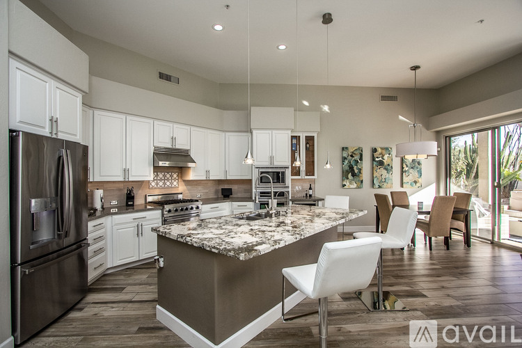 A modern kitchen with a center island and stainless steel appliances.